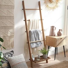 a wooden ladder leaning against the wall next to a potted plant in a living room