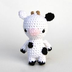 a small crocheted cow sitting on top of a white table