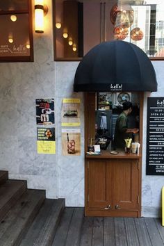 a coffee shop with an umbrella over the counter and menus on the wall behind it