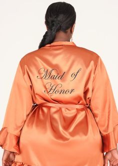 a woman in an orange satin robe with the words maid of honor on her back