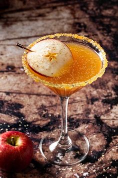 an apple sitting on top of a glass filled with liquid