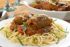 spaghetti with meatballs and tomato sauce on a white plate next to a bowl of pasta