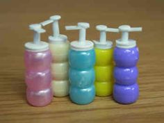 six small bottles with toothbrushes in them sitting on a table next to each other