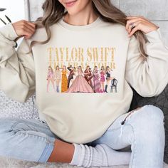 a woman is sitting on the floor wearing a sweatshirt that says taylor swift and other women