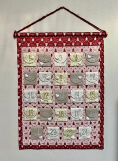 a red and white quilt hanging on a wall