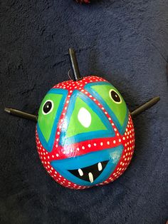 a painted ball on the floor with two eyes and one nose sticking out from it