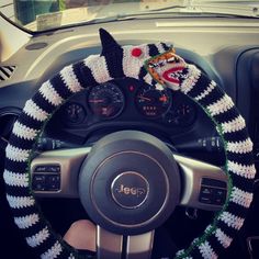 the steering wheel cover is decorated with black and white crochet