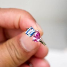 a person holding a pink and blue ring in their left hand with the other hand