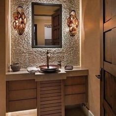 a bathroom with a sink, mirror and lights on the side of the wall in front of it