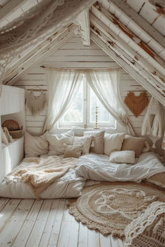 an attic bedroom with white walls and wood flooring is furnished with natural materials such as blankets, rugs and pillows