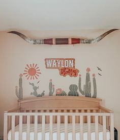 a baby's room with a crib and wall decals