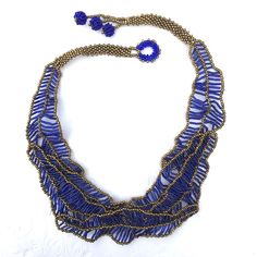 a blue and gold beaded necklace on a white background