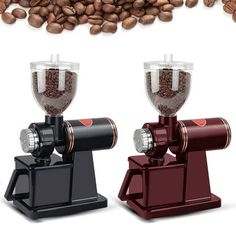 two coffee grinders sitting next to each other on top of a pile of coffee beans