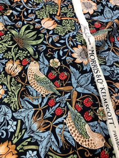 the fabric has birds and berries on it, with words written in white writing below