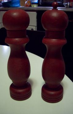 two red candlesticks sitting on top of a white table next to a counter