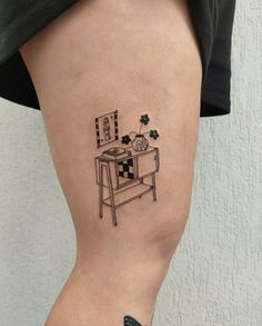 a woman's leg with a tattoo on it that has an image of a desk and flowers