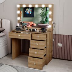 a dressing table with drawers and lights on it in front of a wall mounted mirror