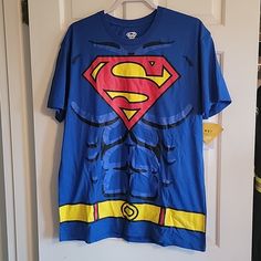 a blue superman t - shirt hanging on a door