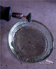 a close up of a glass bowl with water in it and an object on the ground