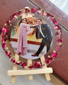 a glass plate with an image of a man and woman on it sitting on a wooden easel