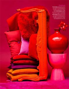 a pile of pillows and vases sitting next to each other on a pink surface