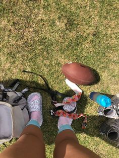 a person's feet and sports equipment on the grass