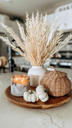 a tray with candles and some white pumpkins