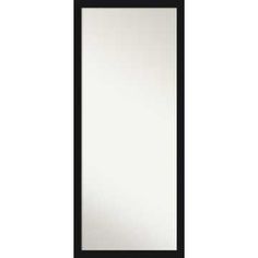 a black framed mirror on a white wall