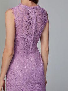 a woman in a purple lace dress looking back at the camera with her hand on her hip