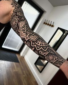 a man's arm with an intricate tattoo design on the arm and shoulder area