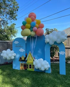 a house made out of cardboard with balloons attached to it