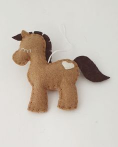 a brown felt horse ornament on a white surface