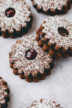 several cookies with powdered sugar and jelly on top are arranged in the shape of snowflakes