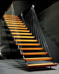 a wooden stair case with strings hanging from it