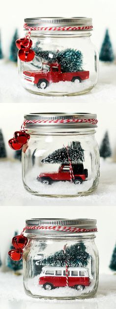 three glass jars with christmas decorations and trees in them on top of snow covered ground