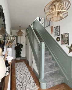 the stairs in this house have been painted green and are lined with pictures on the wall