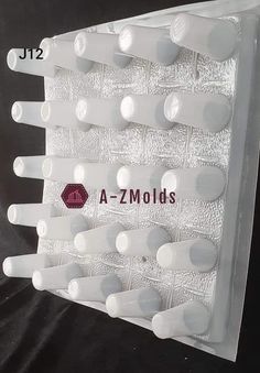 a - z molds white plastic teeth with holes in the middle and bottom, on a black background