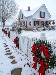 a white picket fence covered in christmas wreaths