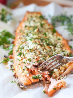 a close up of a piece of salmon on a plate with a fork in it