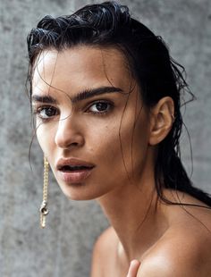 a close up of a person with very large earrings on her head and one eye open