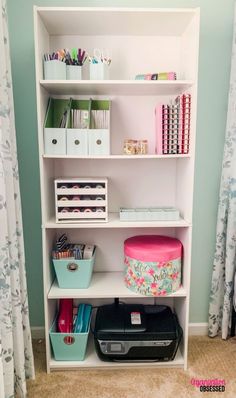 a white book shelf filled with lots of books and office supplies on top of carpeted floor