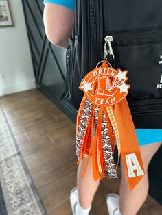 a person holding a bag with an orange ribbon around their neck and the number 4 on it