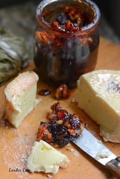 a piece of cheese sitting on top of a wooden cutting board next to a knife