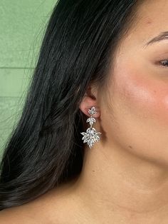 a close up of a person wearing some kind of earring with flowers on it