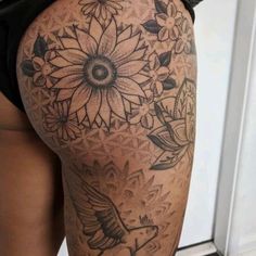 the back of a woman's thigh with flowers and birds tattoo on her leg