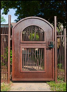 an old iron gate that has been turned into a decorative entrance to a garden area