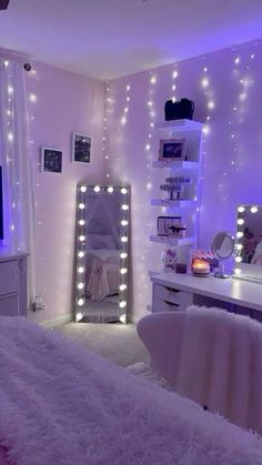 a bedroom decorated in white and purple with lights on the walls, a bed, desk, mirror and chair