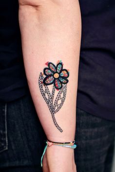 a woman's arm with a tattoo on it and a flower in the middle