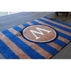 a blue and brown door mat with the letter m on it