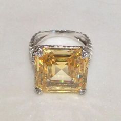 Size 7 This Montana Ring From Judith Ripka Is Gorgeous. It Has A Large Asscher Cut Canary Crystal. It Looks So Clean And Perfectly Cut. You Just Want To Stare At It. I Don't Have The Exact Carat Weight But It Measures At The Top 5/8 Of An Inch Square. It Is Quite The Centerpiece Of This Ring. The Prongs Are Heart Shaped And Have White Sapphire Stones In The Center Of Each Heart. The Ring Is Textured With Her Signature Rope And Berge Motifs. The Hallmarks Are Inside The Band. It's A Stunner !! Diamonique Rings, Swiss Blue Topaz Ring, Sapphire Stones, Emerald Cut Rings, Judith Ripka, Asscher Cut, Diamond Simulant, Lemon Quartz, Sapphire Stone